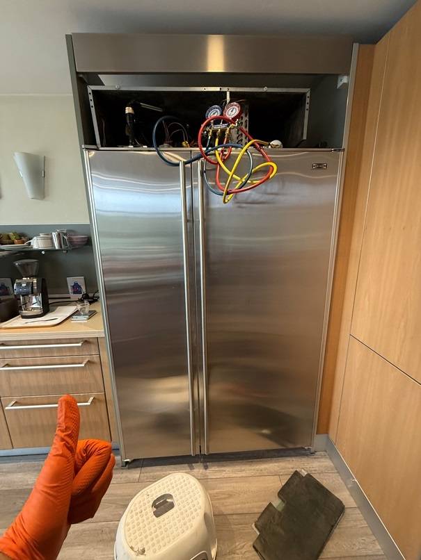 Gauge manifold connected to the sealed system of a built-in refrigerator with the top grille open during a Spark repair
