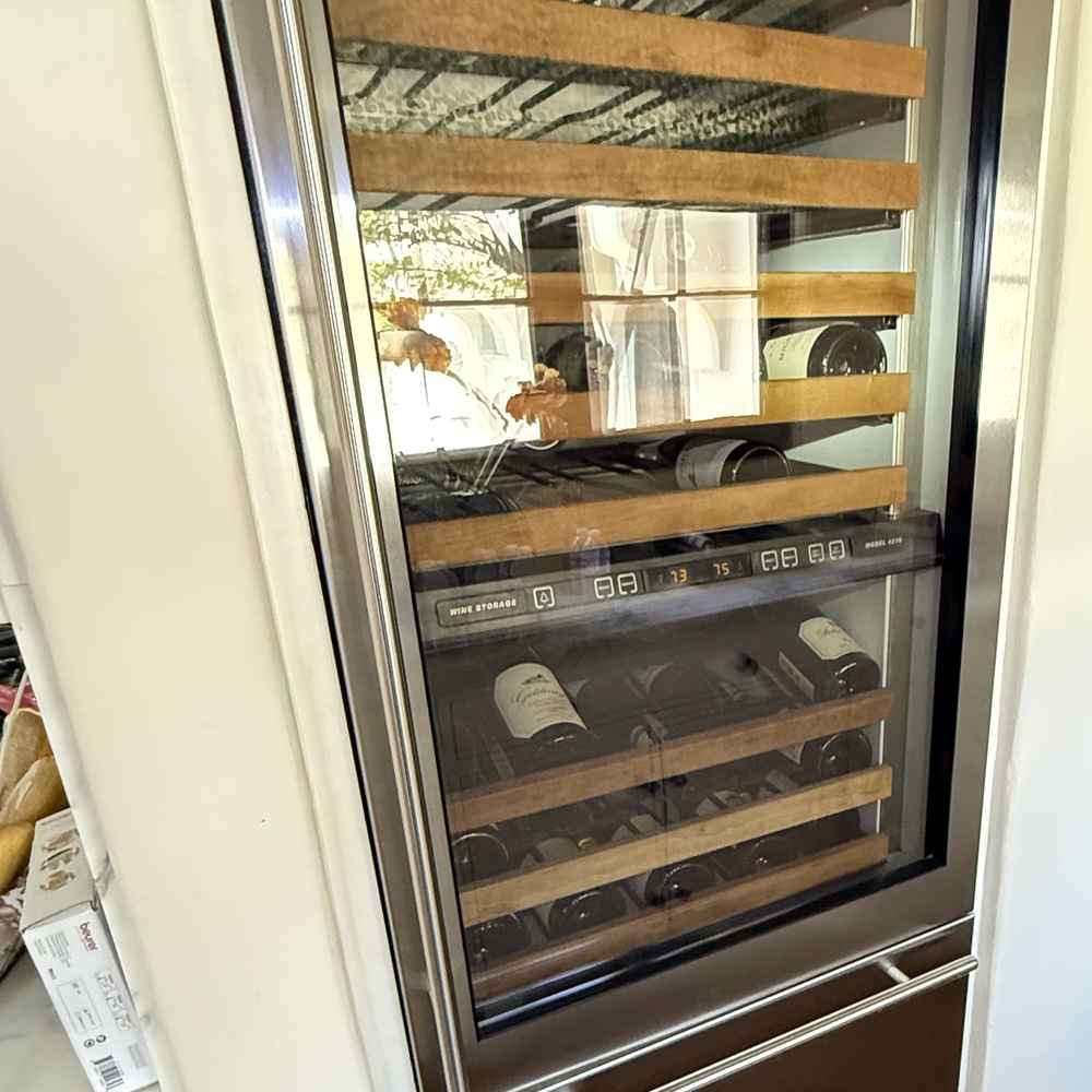 Built-in dual-zone wine cooler column with a wine drawer and bottles on wood shelves, repaired in San Diego &mdash; Spark Appliance Repair