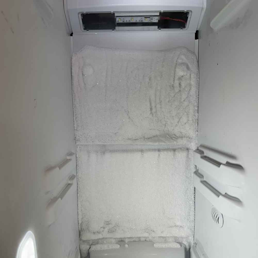 Heavy frost buildup on the rear evaporator wall of a freezer from a failed defrost system in San Diego &mdash; defrost-system repair by Spark Appliance Repair