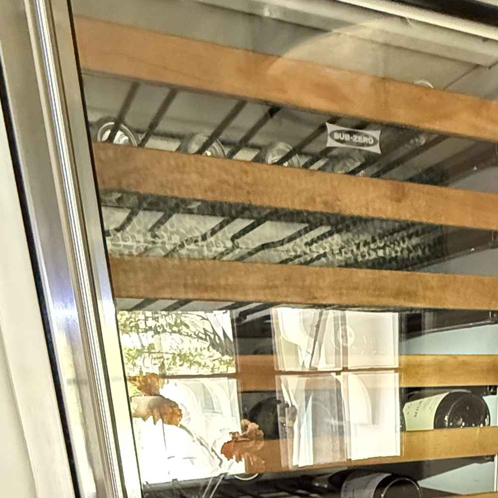 Wine bottles stored on wood shelves inside a dual-zone wine cooler in San Diego &mdash; Spark Appliance Repair