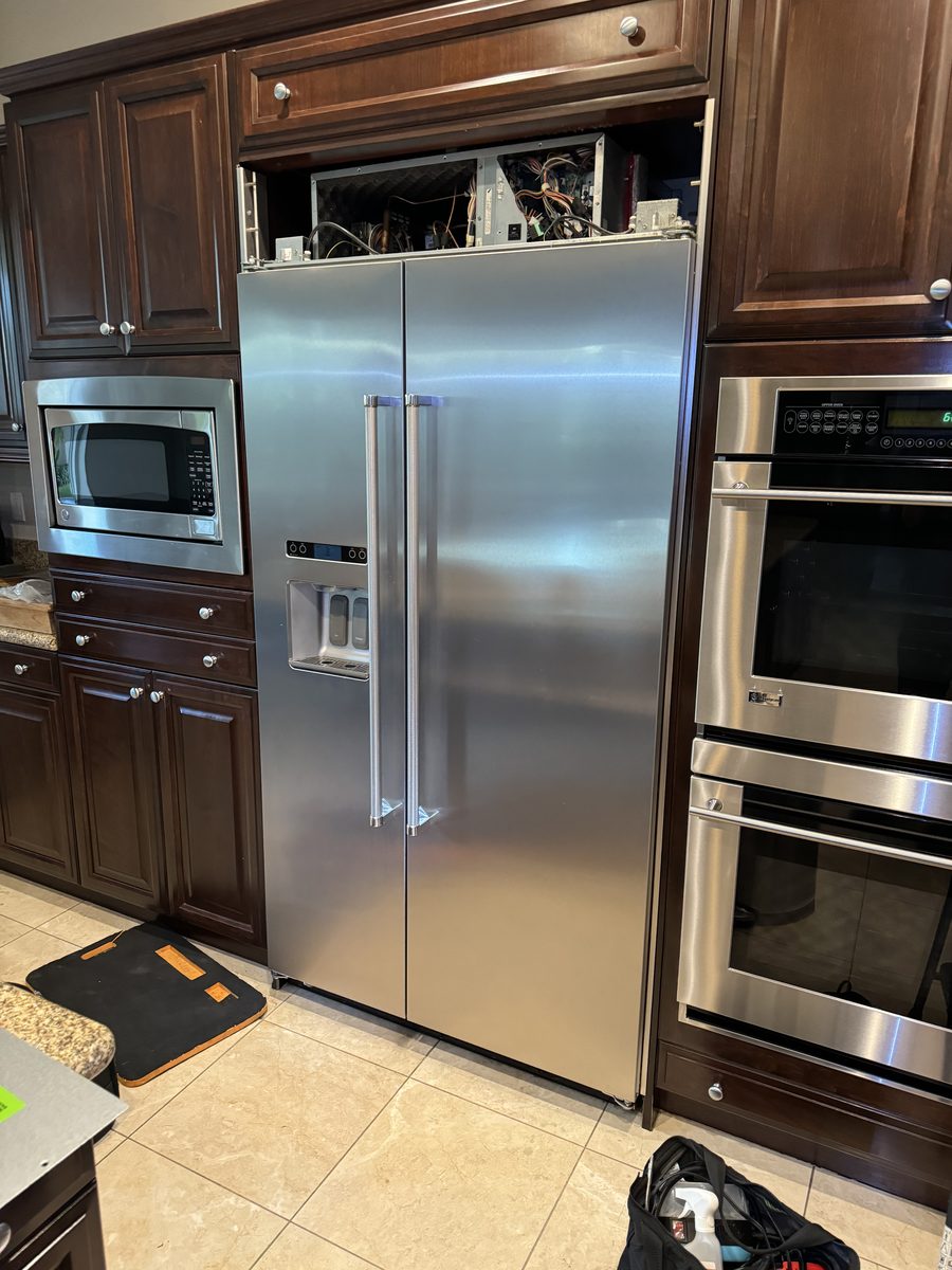 Built-in refrigerator with its upper machine compartment opened for diagnosis during a Spark cooling repair in San Diego