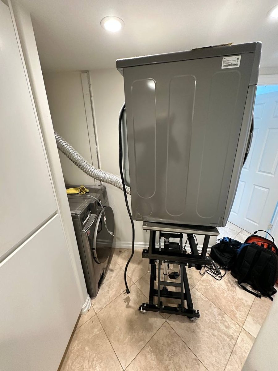 Dryer raised on a service lift with the vent duct visible during a Spark repair in San Diego