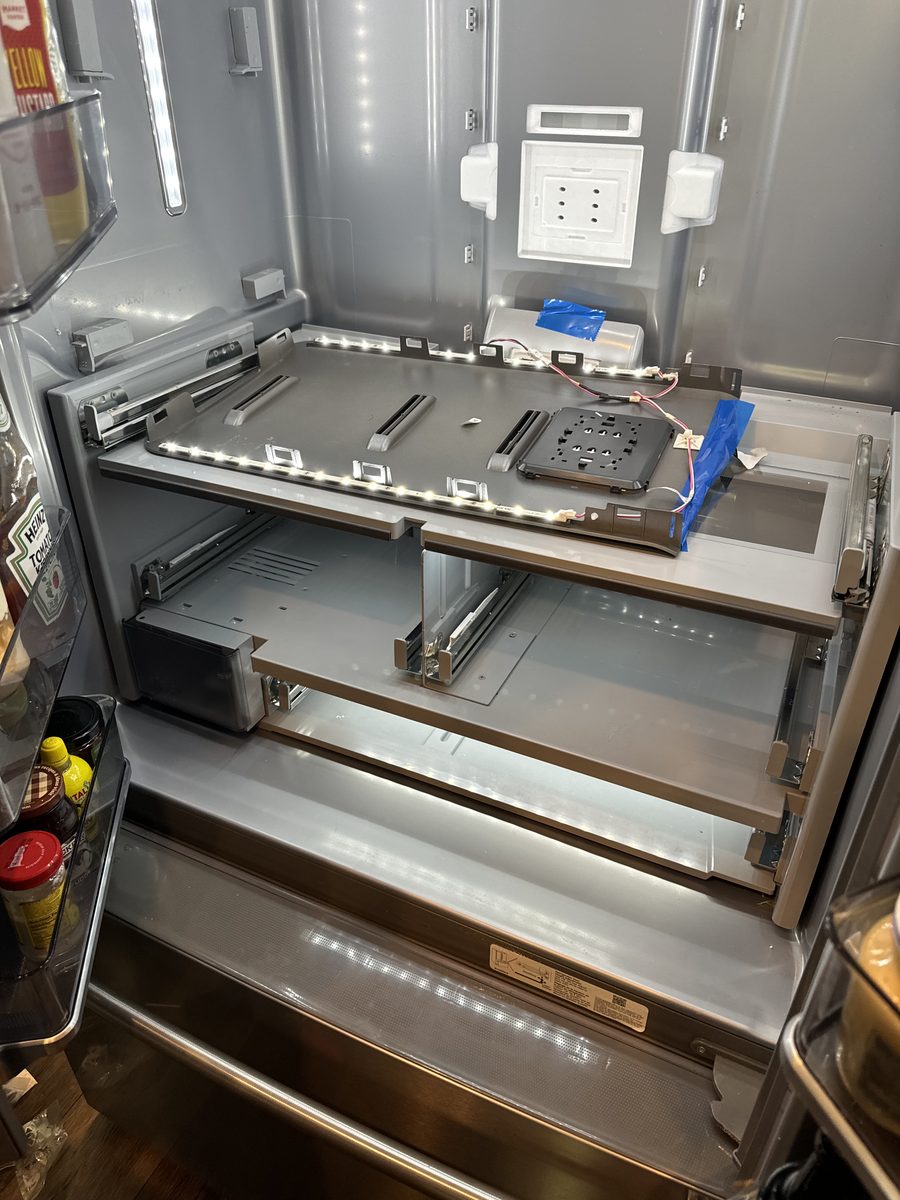 Inside of a French-door refrigerator with the shelves and rear panels opened up during a Spark cooling repair in San Diego