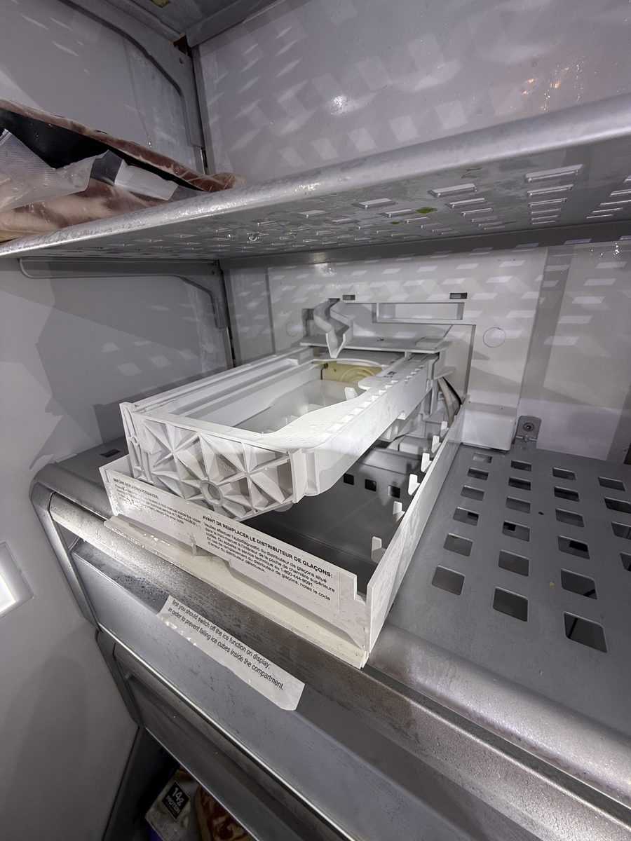 Ice maker assembly tilted out of its housing during a Spark ice maker repair
