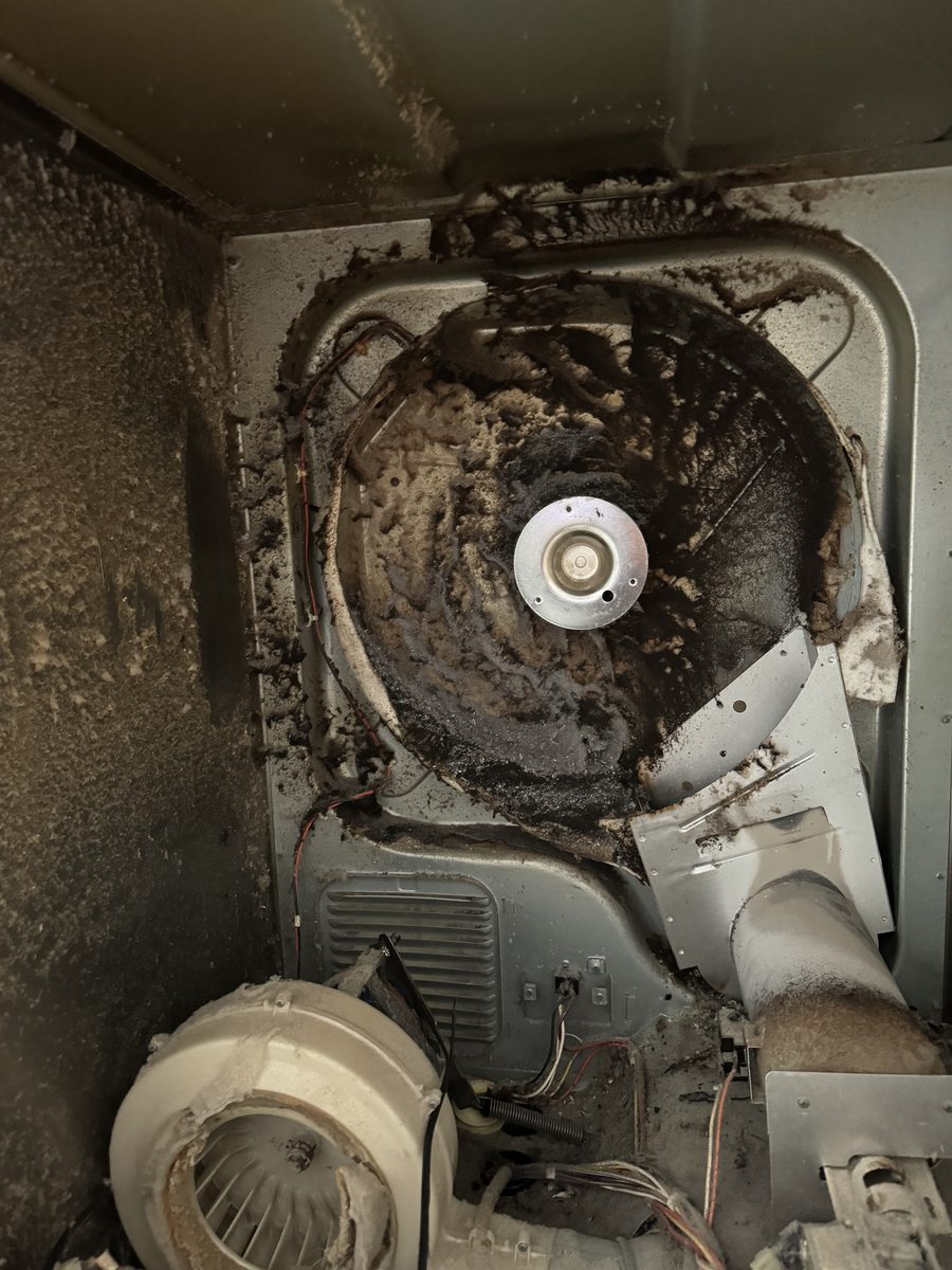Dryer blower housing packed solid with lint, found during a Spark dryer repair in San Diego