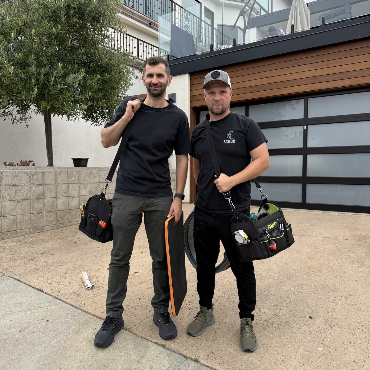 Two Spark Appliance Repair technicians arriving at a San Diego home with their tool bags