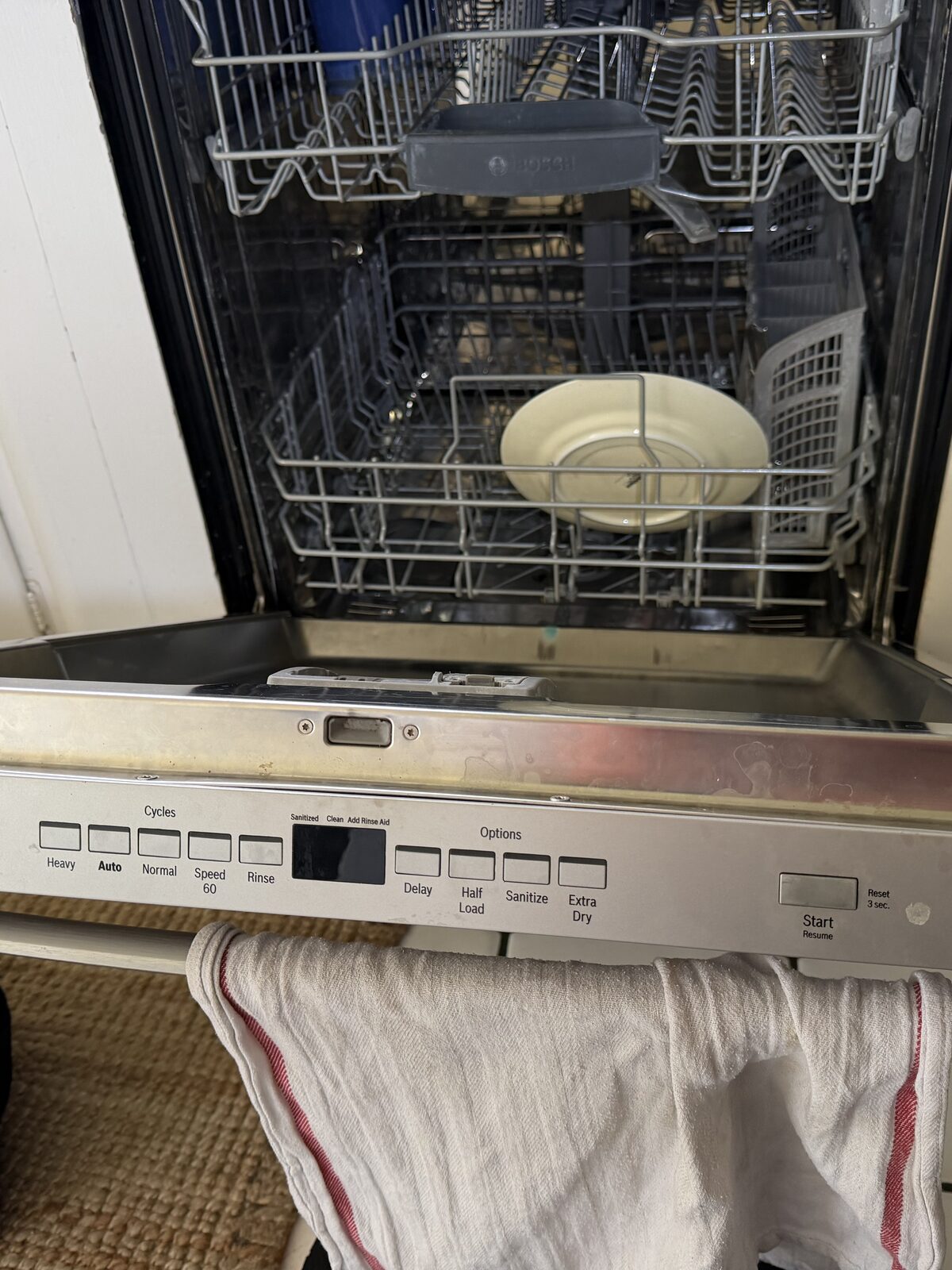 Bosch front-control dishwasher with the door open and both racks in place during a Spark service visit in La Mesa