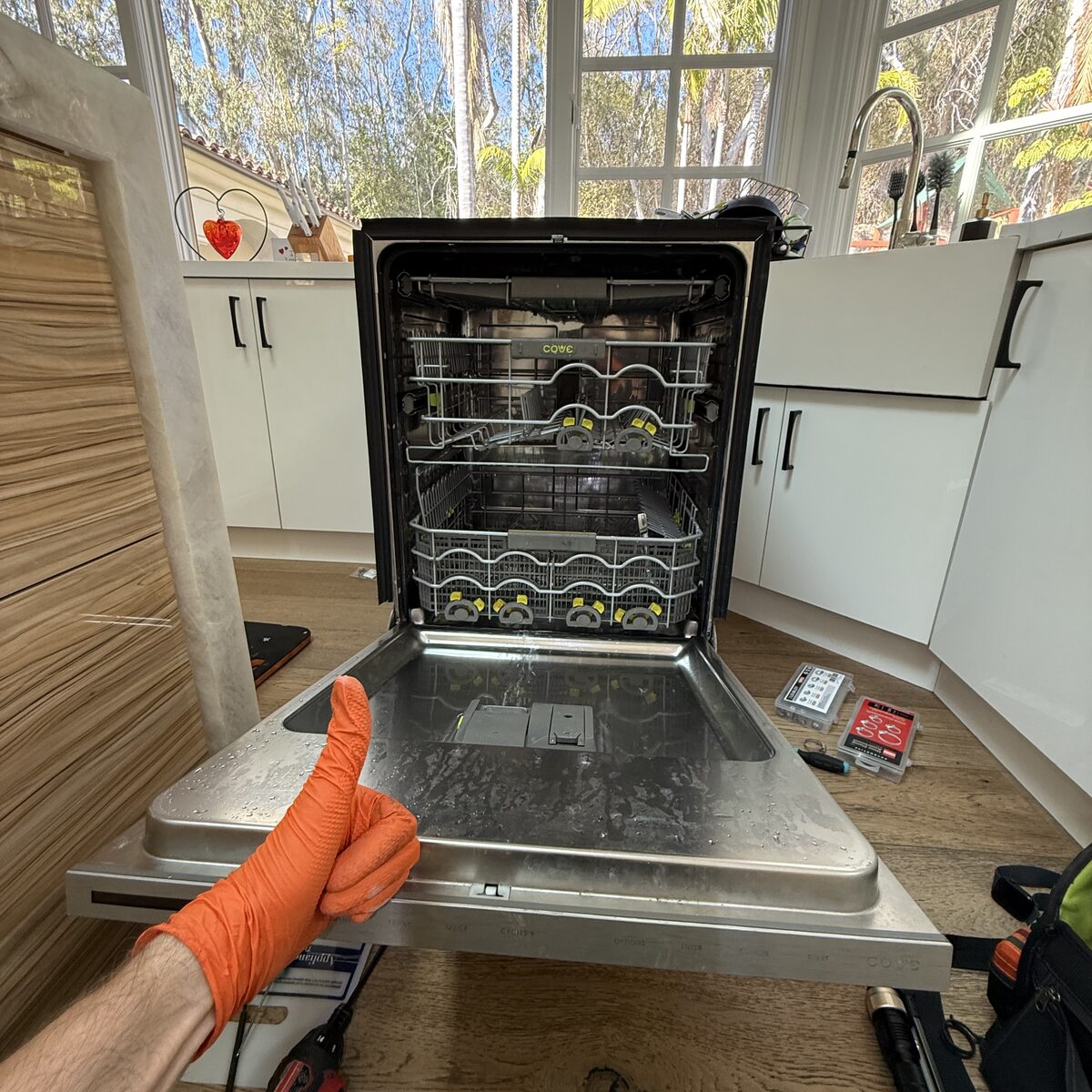 Dishwasher with the door open and both racks in view during a Spark Appliance Repair service call in Encinitas