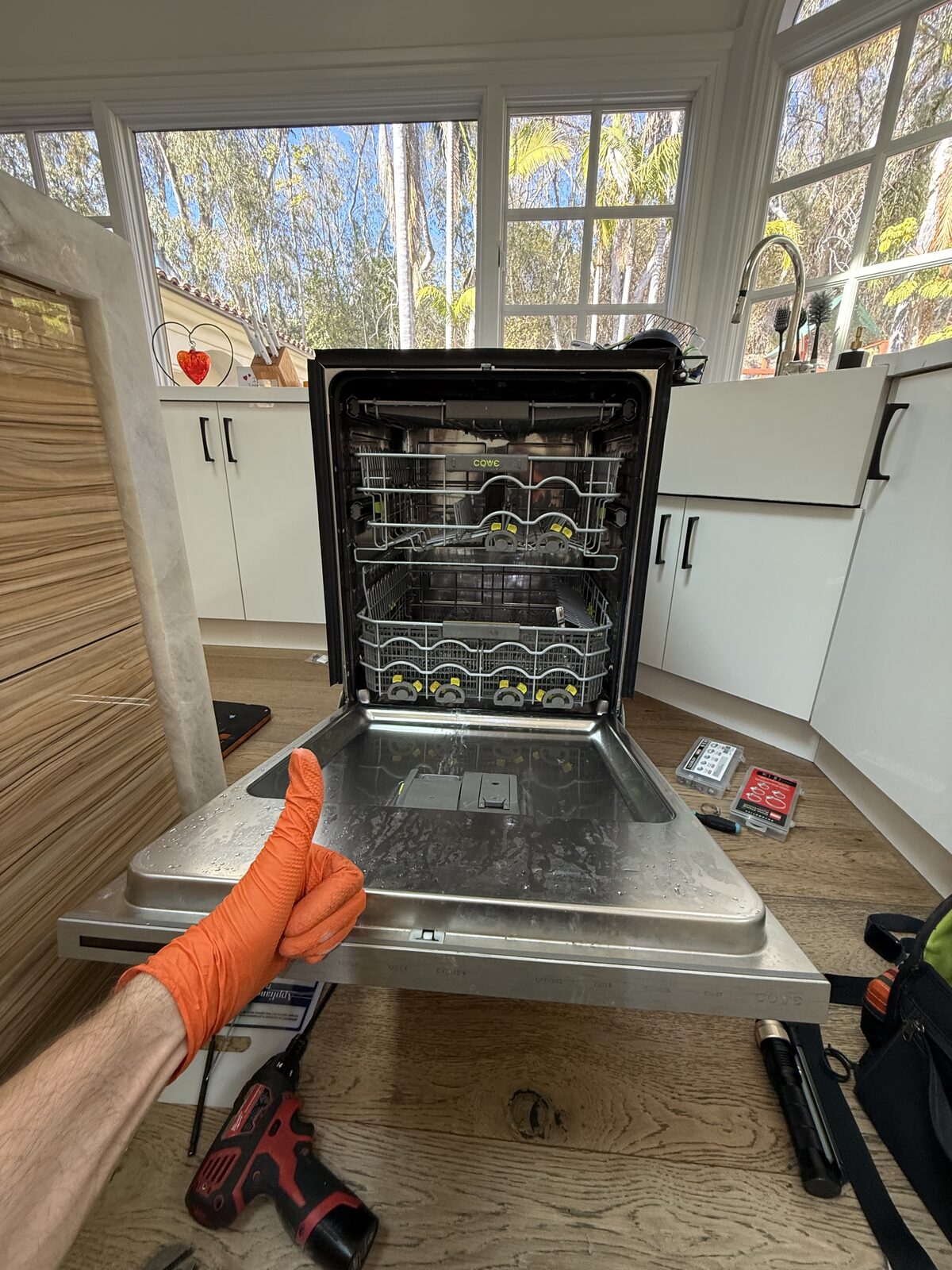 Dishwasher with the door open and lower rack pulled out during a Spark hard-water descale on a North San Diego County call