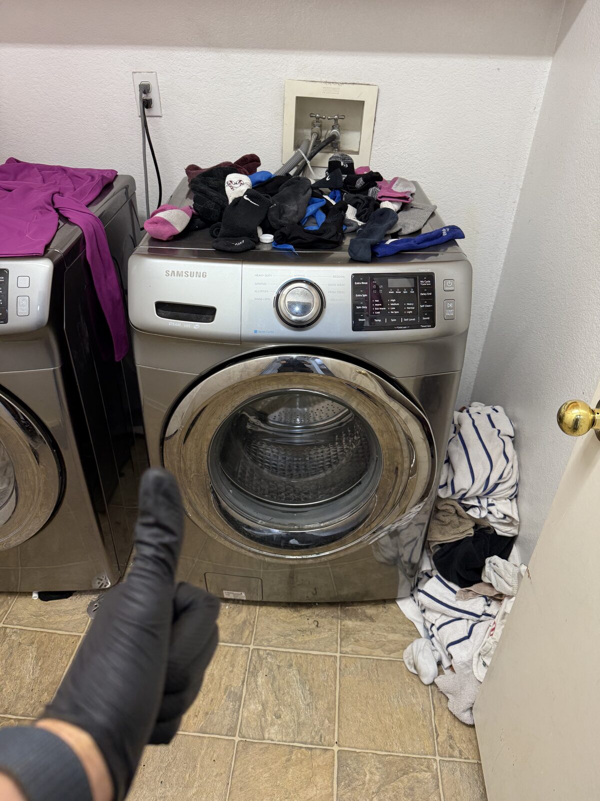 Samsung front-load washer with the door open and the laundry set aside on a Spark service visit