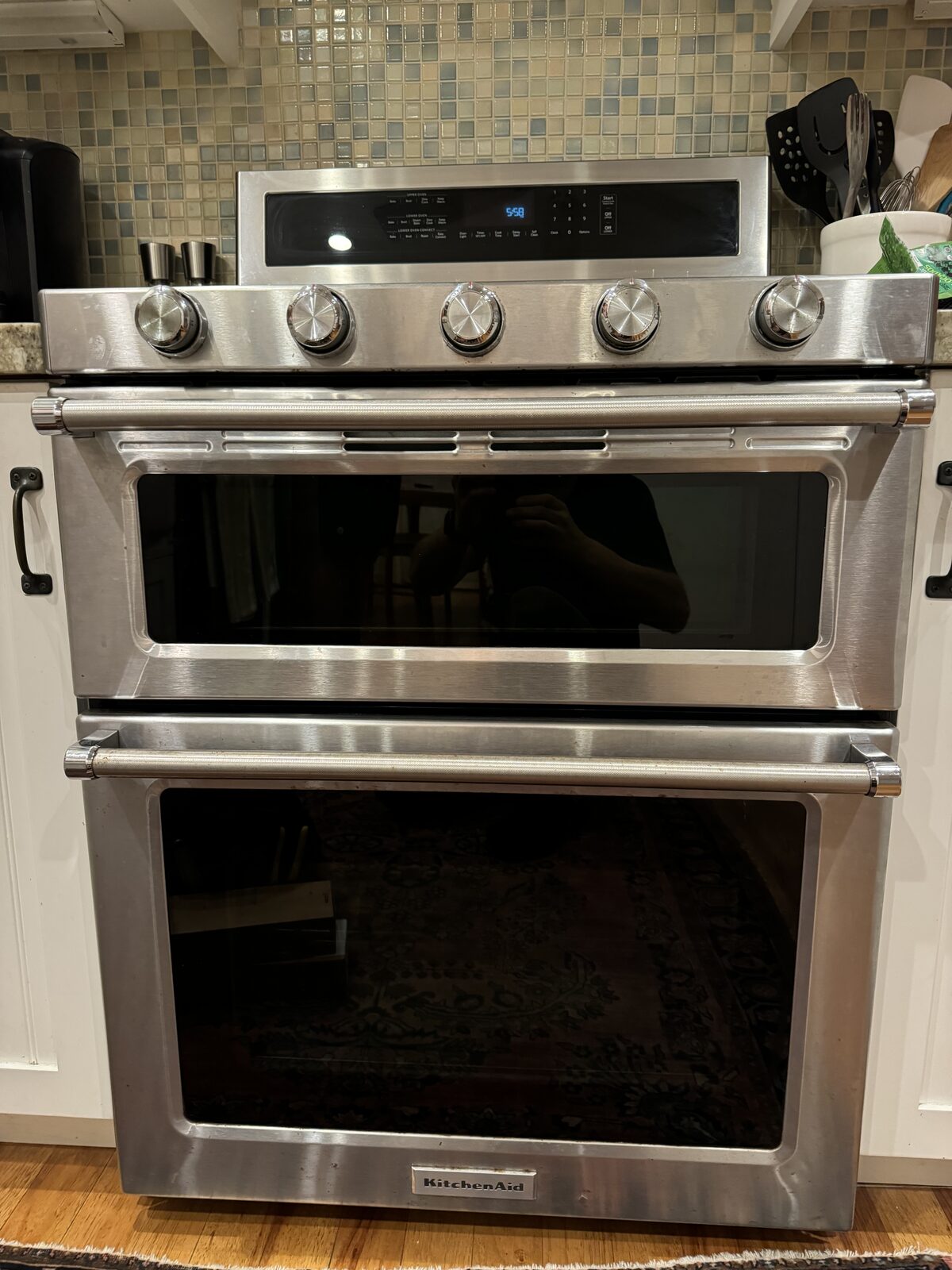 Stainless KitchenAid double-oven range with upper and lower oven doors in a tiled kitchen