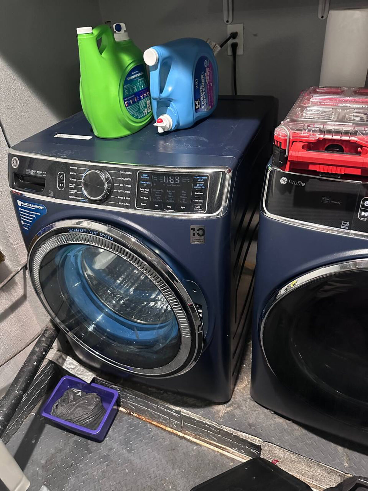 Navy Samsung front-load washer in a garage laundry area on a Spark Appliance Repair service call