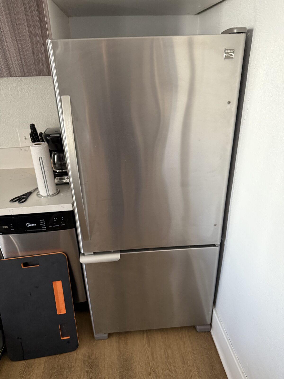 Stainless bottom-freezer refrigerator in a compact downtown San Diego kitchen on a Spark service call