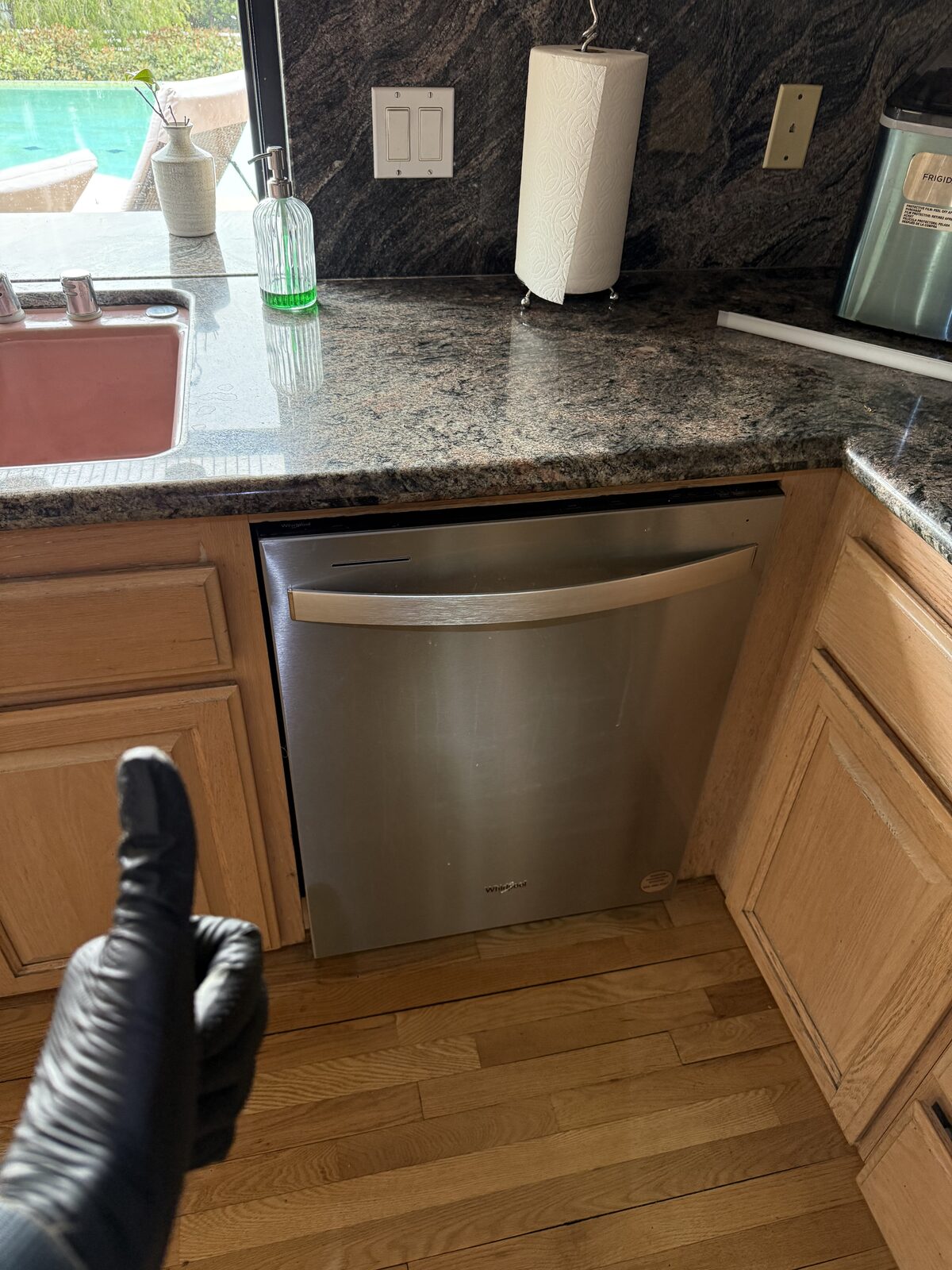 Whirlpool stainless steel dishwasher under a granite counter in a North County San Diego kitchen on a Spark service call